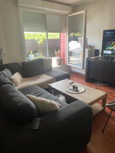 un salon avec un canapé et une table basse dans l'établissement Appartement 2 chambres, à Artigues-près-Bordeaux
