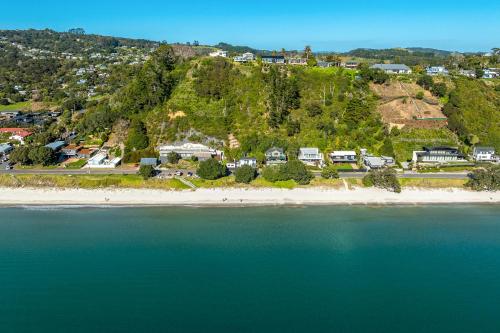 an aerial view of a beach with houses and trees at Onetangi Clifftop, Onetangi - Be My Guest Waiheke in Onetangi
