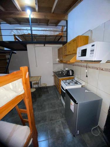 a small kitchen with a stove and a microwave at VMdormis in Neuquén