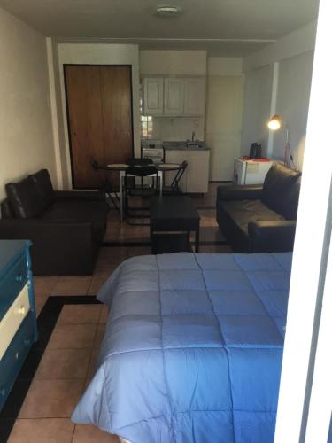 a living room with a blue bed and a couch at Terraza y sol in Buenos Aires