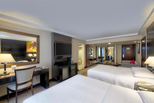 a hotel room with two beds and a desk at Islamabad Marriott Hotel in Islamabad
