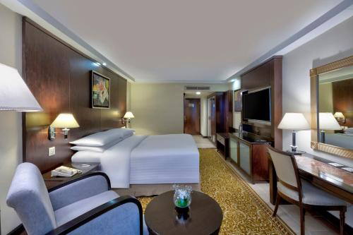a hotel room with a large bed and a living room at Islamabad Marriott Hotel in Islamabad