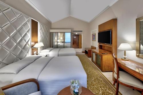 a hotel room with a large bed and a television at Islamabad Marriott Hotel in Islamabad