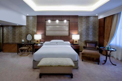 a bedroom with a large bed and a desk and chair at Islamabad Marriott Hotel in Islamabad