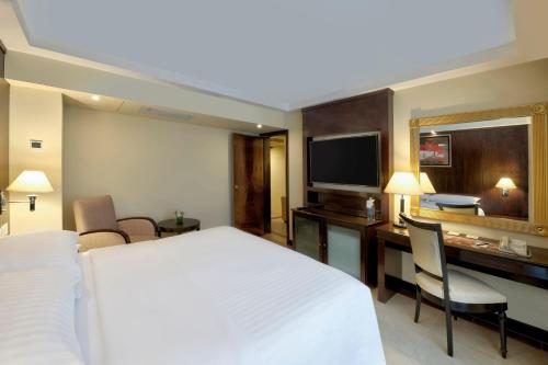a hotel room with a bed and a desk and a television at Islamabad Marriott Hotel in Islamabad