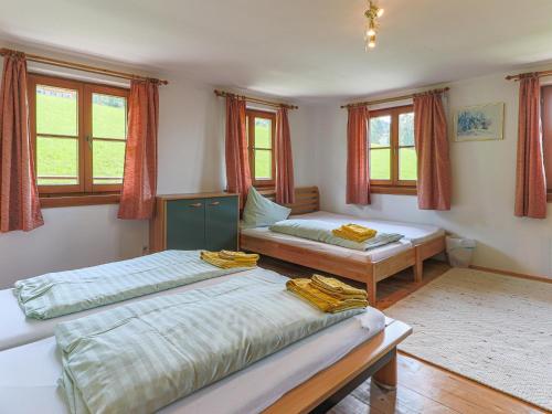 two beds in a room with windows at Feilgrub 2 in Bichling