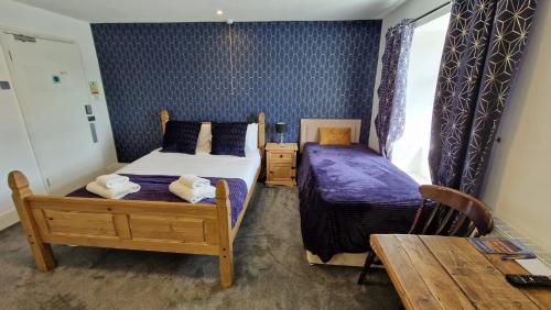 a bedroom with two beds and a table and a table at The White Lion Hotel, Church Road, Yate BS37 5BG Self-check-in FREE PARKING Walk away from the centre of Yate! in Yate