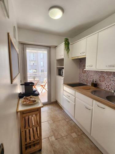 eine Küche mit weißen Schränken und einer Arbeitsplatte in der Unterkunft Cannes Paradis in Cannes