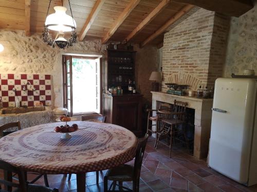 une cuisine avec une table et un réfrigérateur dans l'établissement Villa de charme à Cissac-Médoc, à Cissac-Médoc
