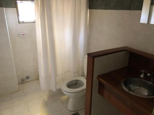 a bathroom with a toilet and a sink at Púrpura Atardecer Hermosa casa de montaña in San Javier