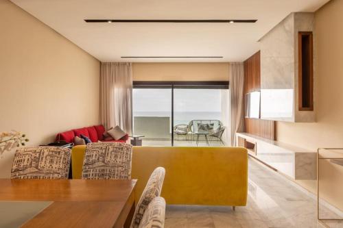 a living room with a yellow couch and a table at Magnifique appartement front mer in Tamaris
