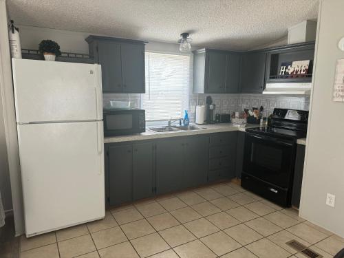 a kitchen with blue cabinets and a white refrigerator at Casita on the Ranch - wildlife, sunsets, stars, Relax in Spring Branch