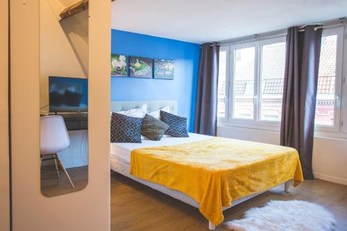 a bedroom with blue walls and a bed with a yellow blanket at Colocation de luxe à Tourcoing avec jardin in Tourcoing