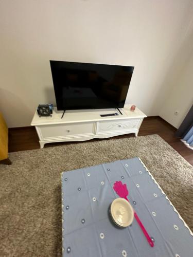 a living room with a flat screen tv and a table at Sunrise apartment in Podgorica
