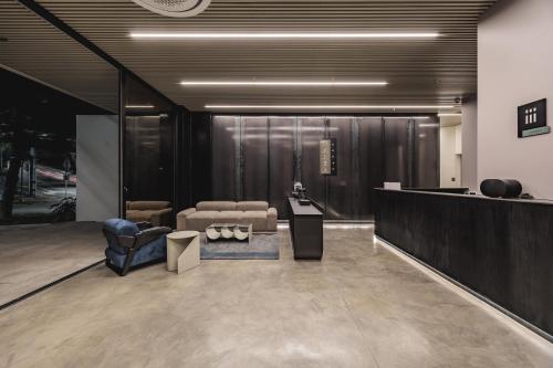 a lobby with a couch and a chair and a table at Nock - Reserved Residences in Medellín