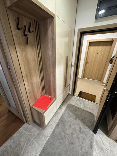a small bathroom with a red bench next to a door at Sunrise apartment in Podgorica