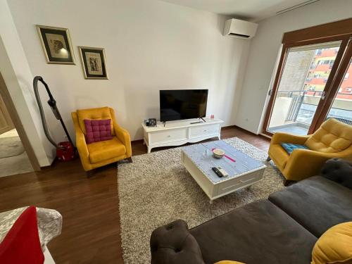 a living room with a couch and a tv at Sunrise apartment in Podgorica