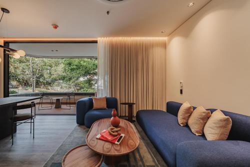 a living room with a blue couch and a table at Nock - Reserved Residences in Medellín