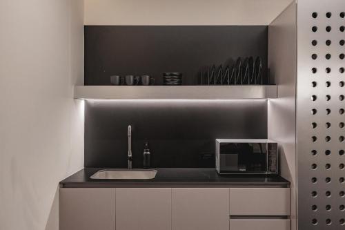 a kitchen with a sink and a microwave at Nock - Reserved Residences in Medellín
