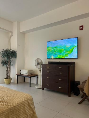 a bedroom with a flat screen tv on a wall at CASA YAYO 1BR condo at Pico de Loro in Nasugbu