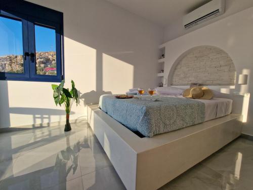 a white bedroom with a bed with a brick wall at Regina - Luxury Apartments in Kalymnos