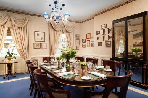 a dining room with a table and chairs and a chandelier at The Old Government House Hotel & Spa in St Peter Port