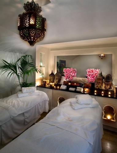 a room with two beds and a mirror at The Old Government House Hotel & Spa in St Peter Port