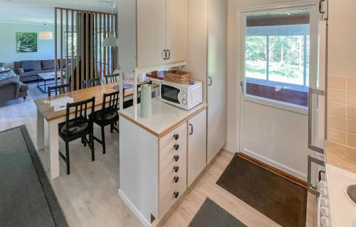 VaggerydにあるAmazing Home In Vaggeryd With Kitchenのキッチン(テーブル、電子レンジ付)