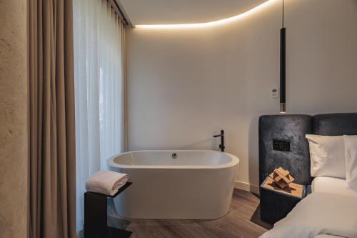 a bathroom with a bath tub next to a bed at Nock - Reserved Residences in Medellín