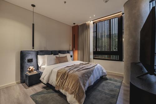 a bedroom with a large bed and a large window at Nock - Reserved Residences in Medellín