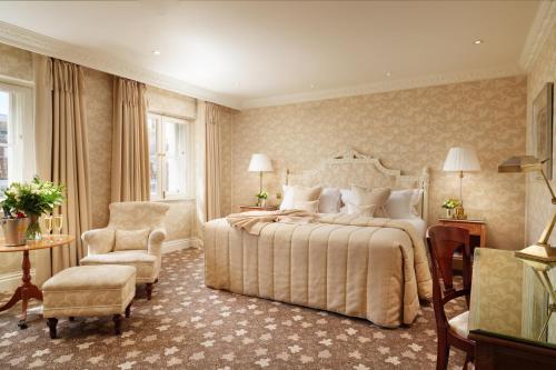 a bedroom with a large bed and a chair at The Old Government House Hotel & Spa in St Peter Port