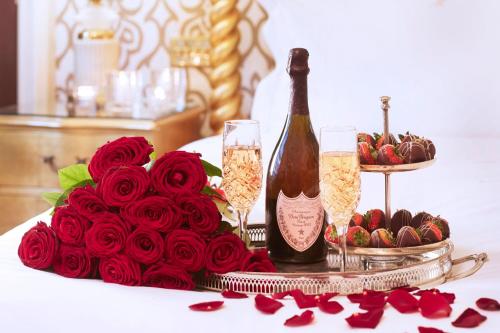 a table with a bottle of champagne and a bouquet of roses at Milestone Hotel Kensington in London