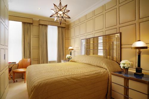 a bedroom with a large bed and a chandelier at Milestone Hotel Kensington in London