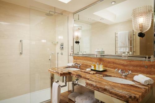 a bathroom with two sinks and a shower at Milestone Hotel Kensington in London