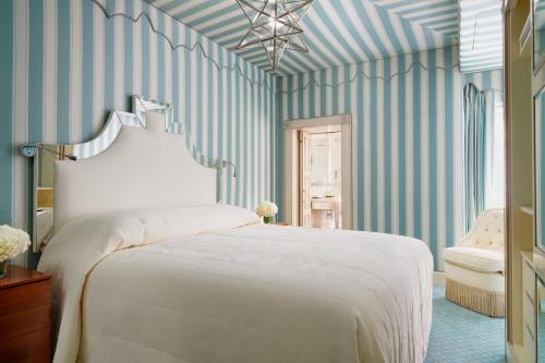 a bedroom with a white bed and striped walls at Milestone Hotel Kensington in London