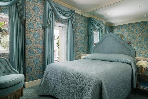 a blue bedroom with a bed and a window at Milestone Hotel Kensington in London