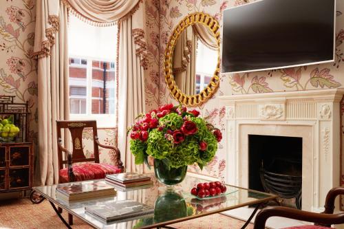 a living room with a vase of flowers on a glass table at Milestone Hotel Kensington in London