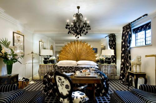 a bedroom with a bed and a table and chairs at Milestone Hotel Kensington in London