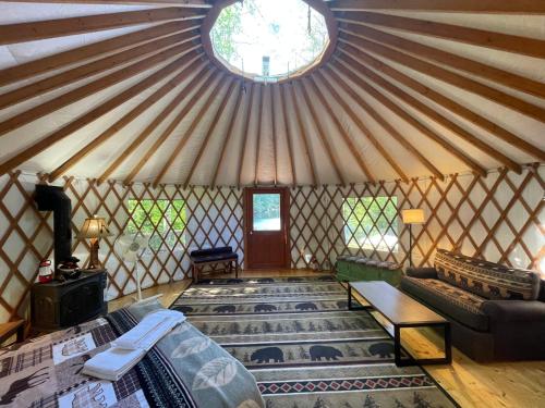 a room with a yurt with a couch and a window at Alderbrook Yurt in Warrensburg
