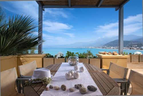 a dining table with a view of the water at Skajado Holiday Apartments in Stalida