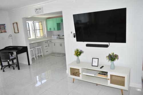 a living room with a flat screen tv on a wall at Irie Vibes Ocean View in Negril