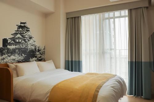 Postel nebo postele na pokoji v ubytování yksi STAY ＆ APARTMENT OSAKA