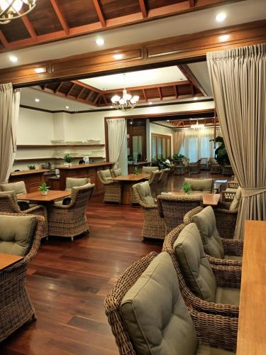 a restaurant with wicker chairs and tables in a lobby at Athena Hotel in Pakse