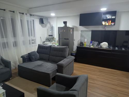 un soggiorno con divano e cucina di Este espaço está disponível somente para locação anual a Canoas