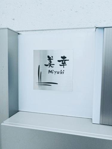 a sign in a white box with writing on it at 下町立石駅近民泊美幸 in Tokyo