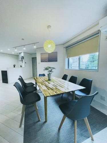 a dining room with a wooden table and chairs at 下町立石駅近民泊美幸 in Tokyo