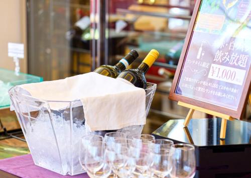 two bottles of wine in a basket next to glasses at Mercure Okinawa Naha in Naha