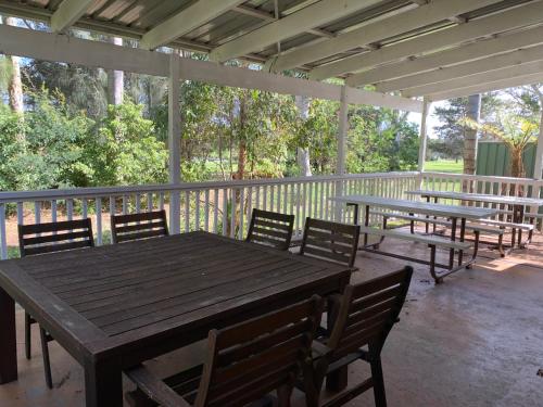 a wooden table and chairs on a screened porch at Golf View Motel in Sanctuary Point