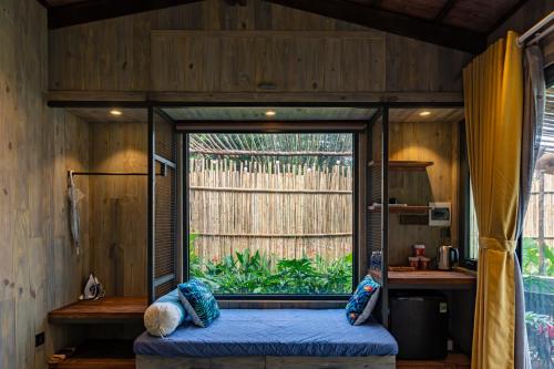 a room with a bed in a room with a window at Nomia Garden Retreats - Khu nghỉ dưỡng hồ Trị An in Xóm Ðốt Ðó
