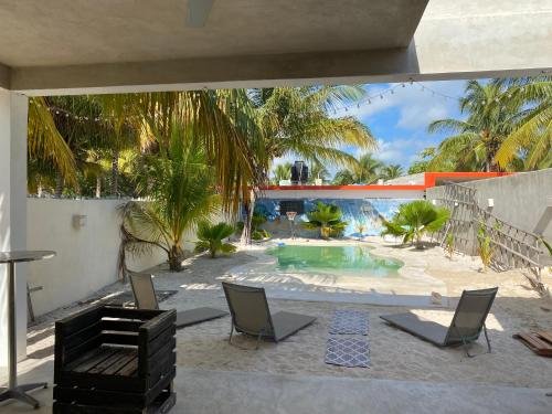 a patio with a table and chairs and a swimming pool at Blue wave in Chelem